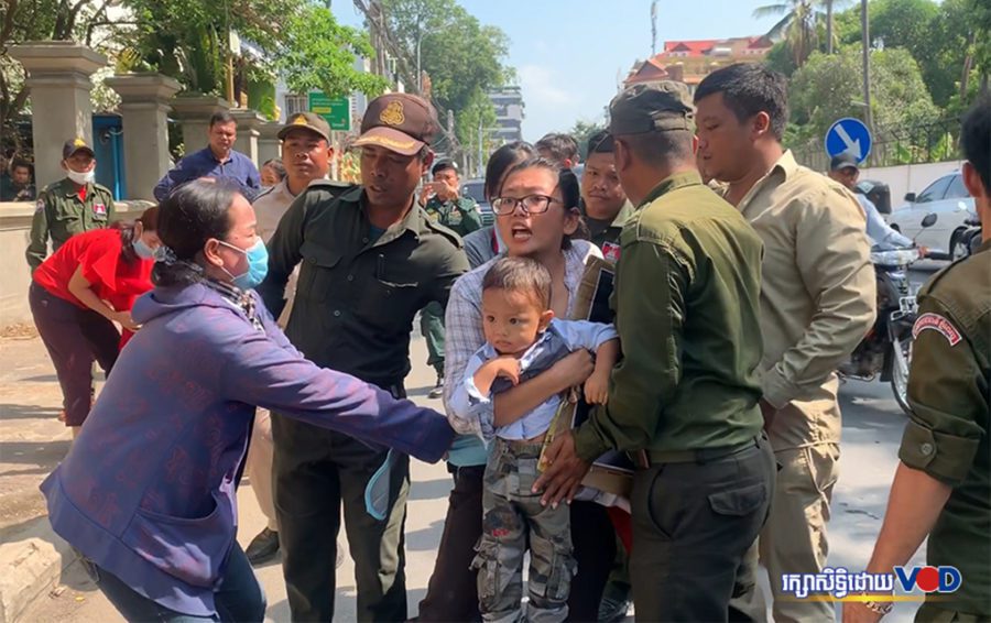 Long Kimheang, the wife of imprisoned translator Rath Rott Mony, holds her son as she is dragged by masked women and authorities while protesting in front of the Russian Embassy in Phnom Penh on April 3, 2019. (Hy Chhay/VOD)