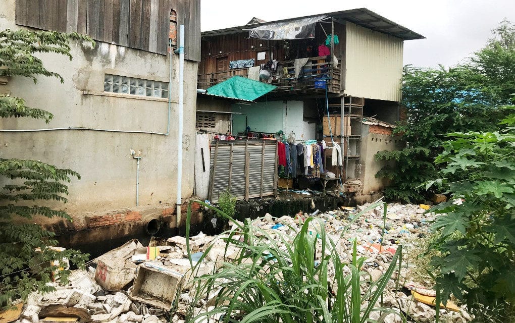 Trash floats on a canal outside houses in Tuol Sangkae commune in Phnom Penh’s Russei Keo district, on September 18, 2019. (Chhorn Sopheap)